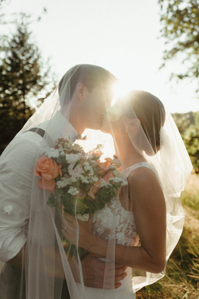 sunny golden hour portrait of bride and groom under the veil 