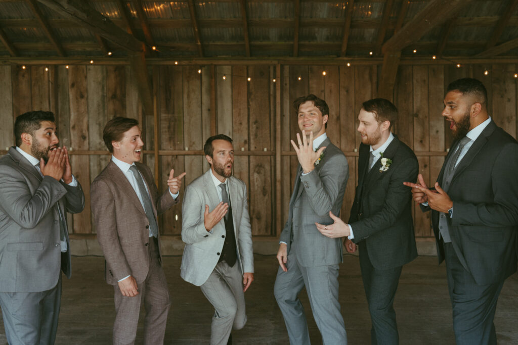 groom getting ready in the cocktail barn with groomsmen