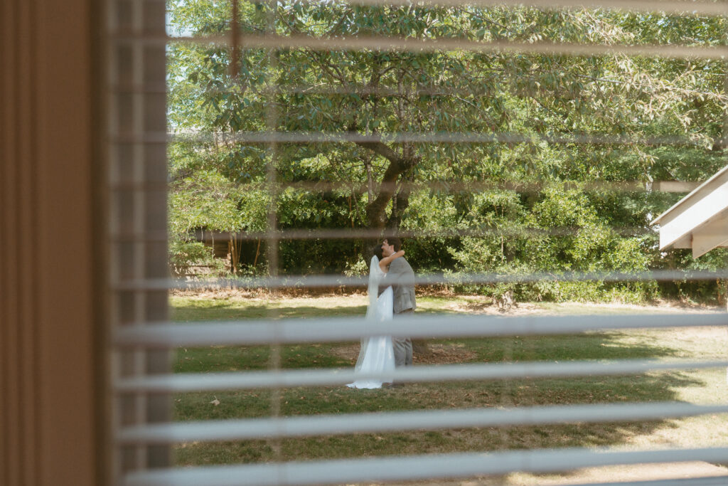 bride and groom sharing a private moment through a window