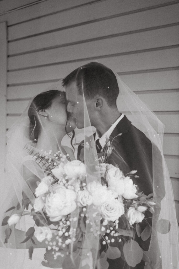 bride and groom kissing under the veil