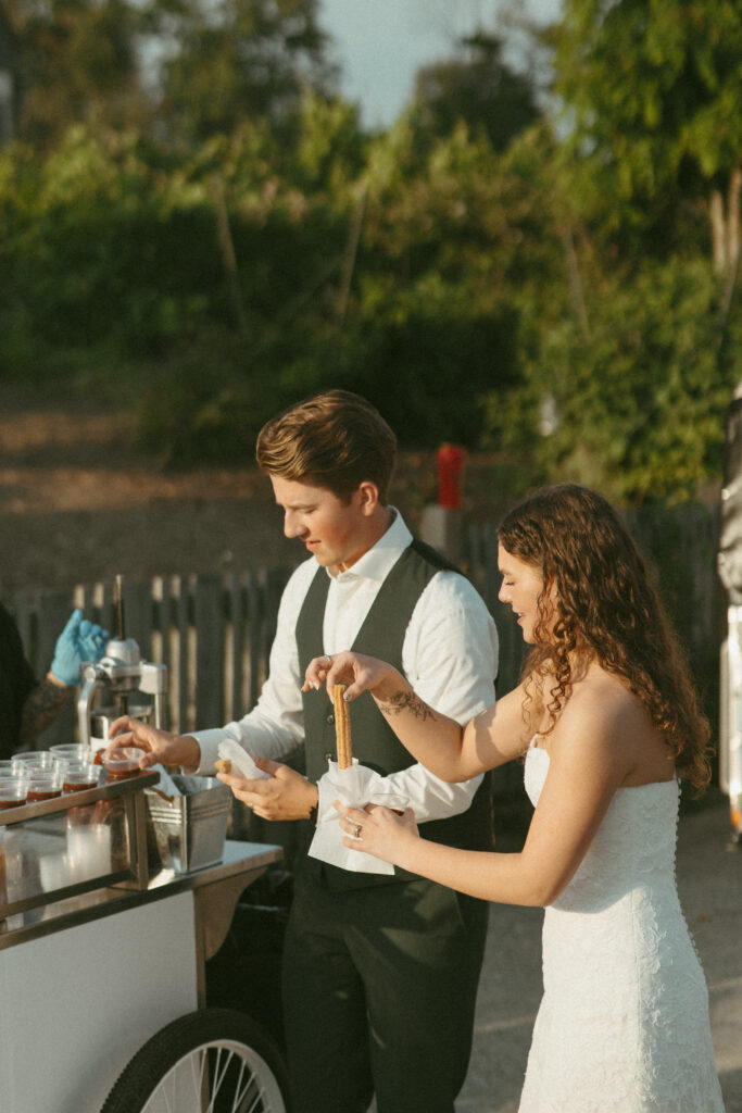 Bride & Groom eating churros at Sage & Solace Wedding Venue in Langley, BC