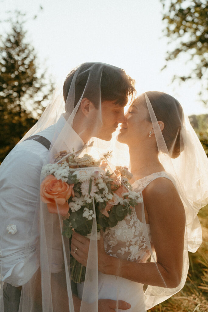 sunny golden hour portrait of bride and groom under the veil 